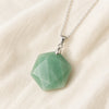 Green Aventurine Hexagon Pendant displayed fully on white silk cloth to show its natural colour, shape and finish