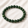 Green Jade Bracelet displayed fully on white silk cloth to show its natural colour, shape and finish