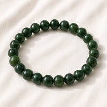 Load image into Gallery viewer, Green Jade Bracelet displayed fully on white silk cloth to show its natural colour, shape and finish
