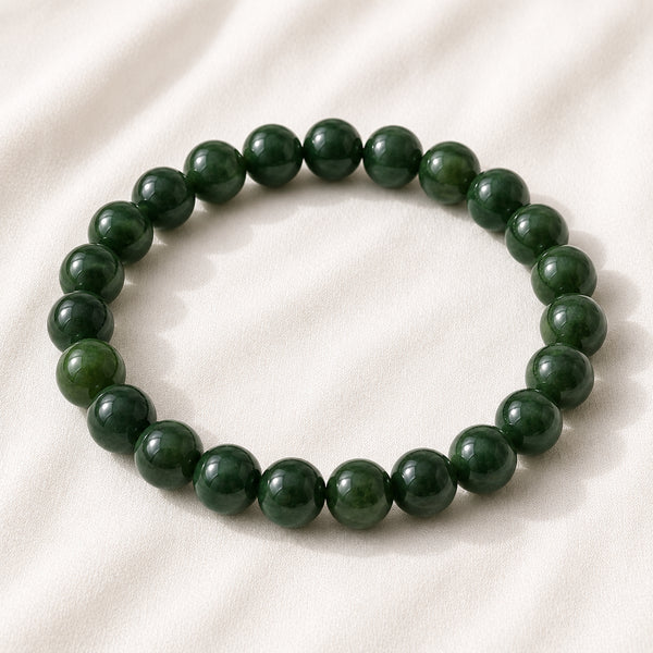 Green Jade Bracelet displayed fully on white silk cloth to show its natural colour, shape and finish
