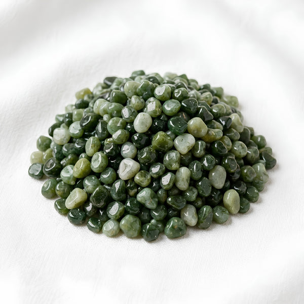 Green Jade Chips displayed fully on white silk cloth to show its natural colour, shape and finish