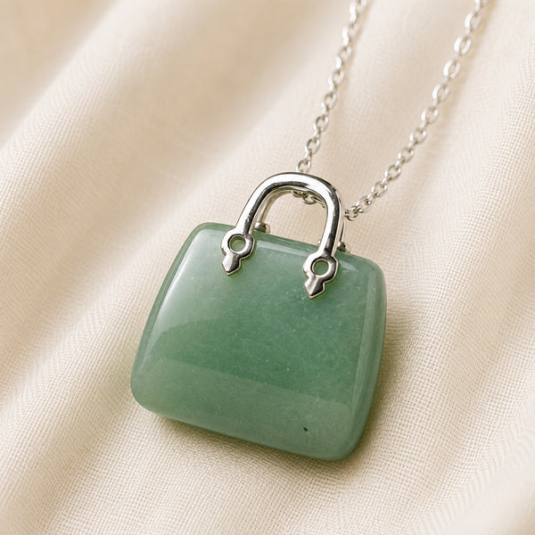 Green Jade Mini Handbag Pendant displayed fully on white silk cloth to show its natural colour, shape and finish