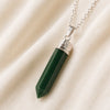 Green Jade Pencil Pendant displayed fully on white silk cloth to show its natural colour, shape and finish