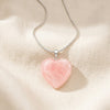 Rose Quartz Heart Pendant displayed fully on white silk cloth to show its natural colour, shape and finish