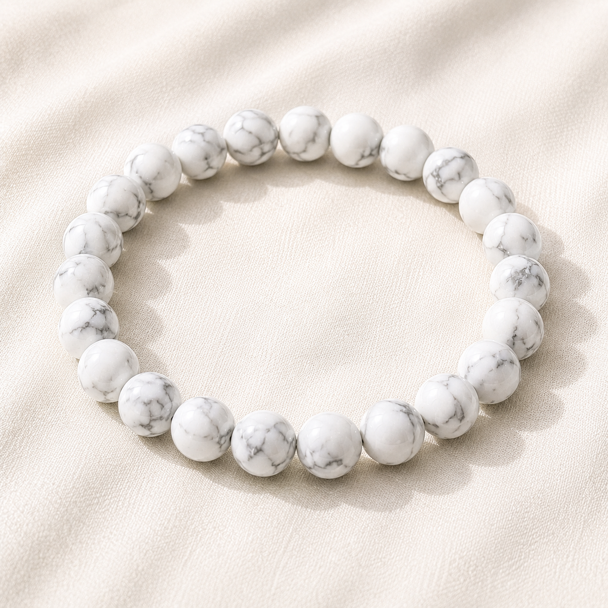 Howlite Bracelet displayed fully on white silk cloth to show its natural colour, shape and finish