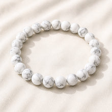 Load image into Gallery viewer, Howlite Bracelet displayed fully on white silk cloth to show its natural colour, shape and finish
