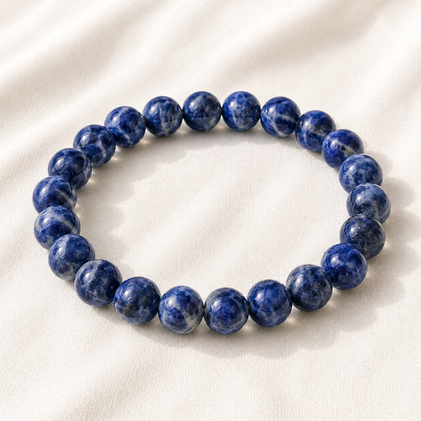 Lapis Lazuli Bracelet displayed fully on white silk cloth to show its natural colour, shape and finish