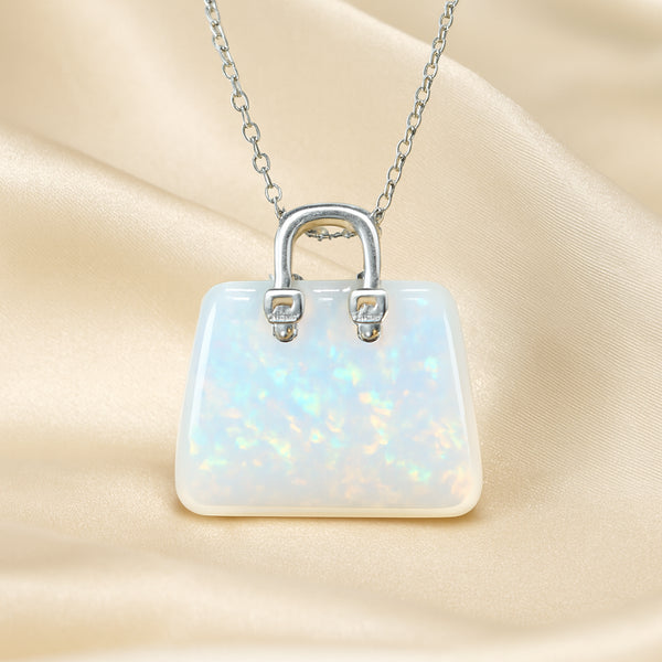 Opal Mini Handbag Pendant displayed fully on white silk cloth to show its natural colour, shape and finish