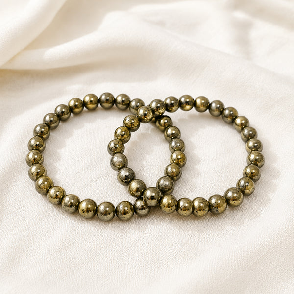Pyrite Bracelet Pack displayed fully on white silk cloth to show its natural colour, shape and finish – pack of 2 pyrite bracelets wealth protection positivity