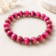 Load image into Gallery viewer, Pink Tiger Eye Bracelet displayed fully on white silk cloth to show its natural colour, shape and finish
