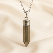 Load image into Gallery viewer, Pyrite Pencil Pendant displayed fully on white silk cloth to show its natural colour, shape and finish
