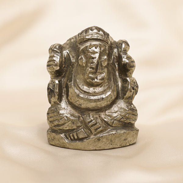 Pyrite Ganesh Idol displayed fully on white silk cloth to show its natural colour, shape and finish