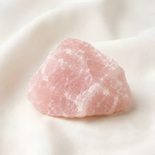 Load image into Gallery viewer, Raw Rose Quartz Raw Stone displayed fully on white silk cloth to show its natural colour, shape and finish
