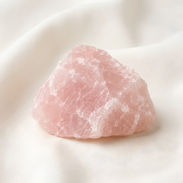 Raw Rose Quartz Raw Stone displayed fully on white silk cloth to show its natural colour, shape and finish
