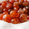 Close-up of authentic natural Carnelian showing crystal texture, colour and craftsmanship – red carnelian chips stone symbol of vitality motivation and