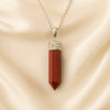 Red Jasper Pencil Pendant displayed fully on white silk cloth to show its natural colour, shape and finish