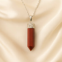 Load image into Gallery viewer, Red Jasper Pencil Pendant displayed fully on white silk cloth to show its natural colour, shape and finish
