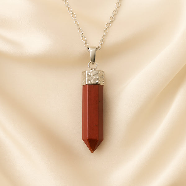 Red Jasper Pencil Pendant displayed fully on white silk cloth to show its natural colour, shape and finish