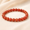 Red Sunstone Bracelet displayed fully on white silk cloth to show its natural colour, shape and finish