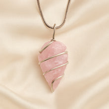 Load image into Gallery viewer, Rose Quartz Arrowhead Pendant displayed fully on white silk cloth to show its natural colour, shape and finish
