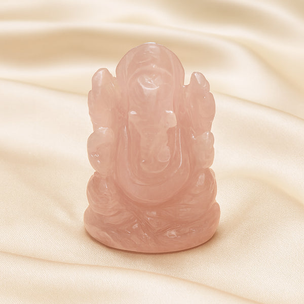 Rose Quartz Ganesh Idol displayed fully on white silk cloth to show its natural colour, shape and finish
