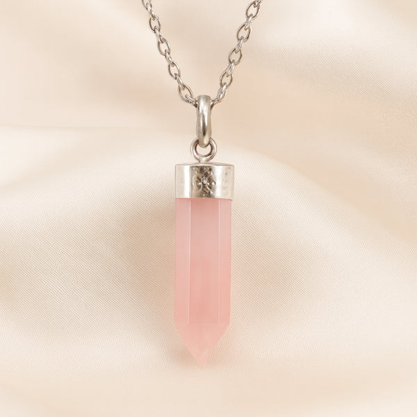 Rose Quartz Pencil Pendant displayed fully on white silk cloth to show its natural colour, shape and finish