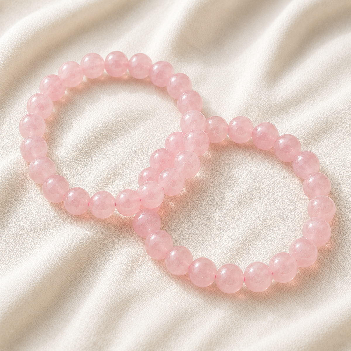 Rose Quartz Bracelet Set displayed fully on white silk cloth to show its natural colour, shape and finish