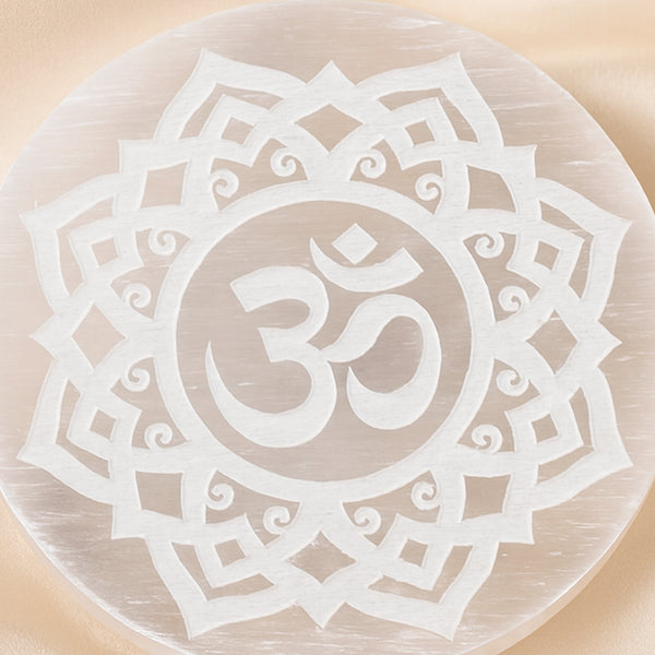 Close-up of authentic natural Selenite showing crystal texture, colour and craftsmanship – selenite charging plate ohm symbol engraved healing energy cleansing