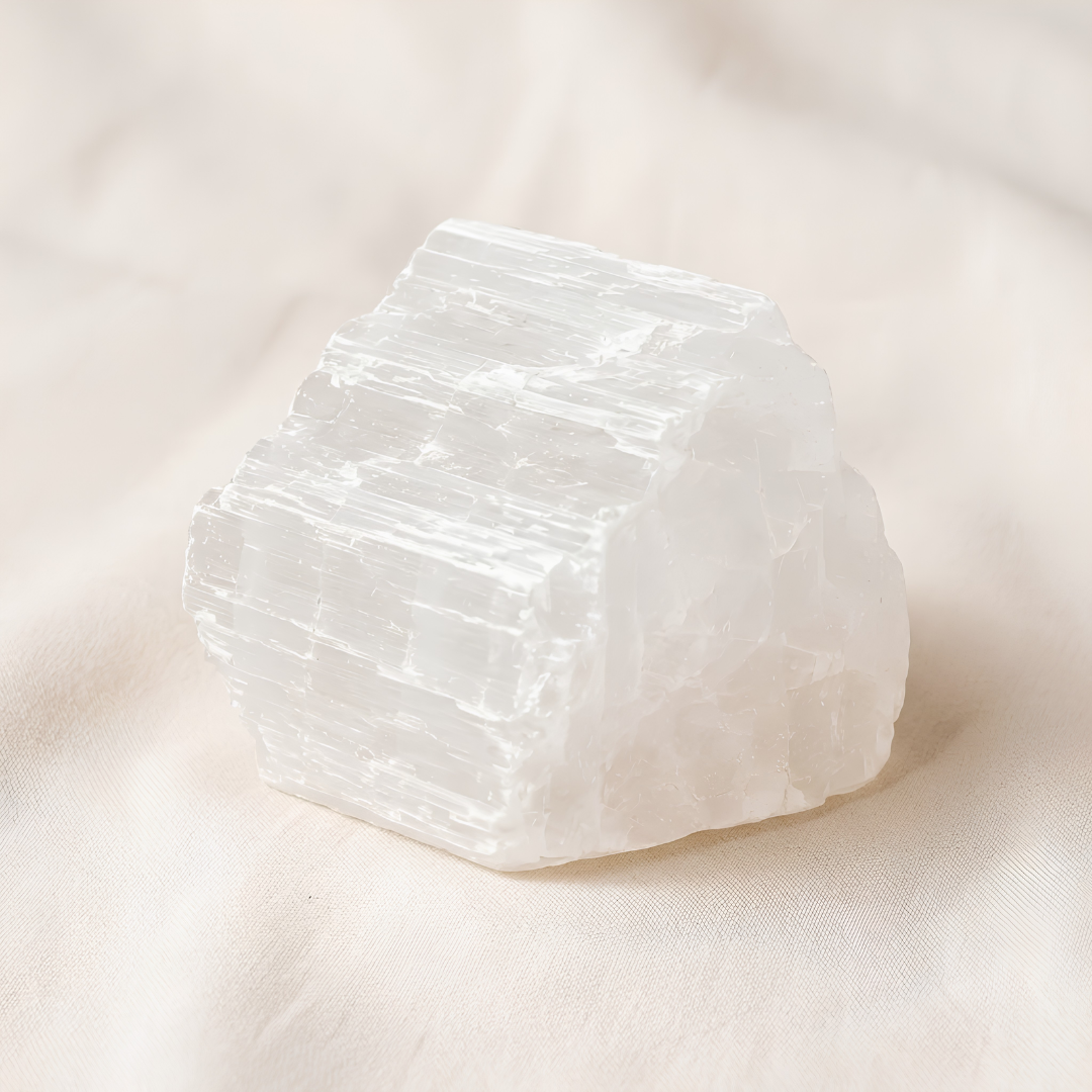 Selenite Raw Stone displayed fully on white silk cloth to show its natural colour, shape and finish