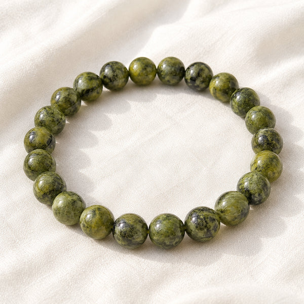 Serpentine Bracelet displayed fully on white silk cloth to show its natural colour, shape and finish
