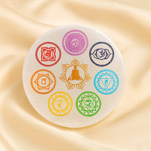 Load image into Gallery viewer, Seven Chakra Selenite Round Charging Plate displayed fully on white silk cloth to show its natural colour, shape and finish
