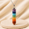 7 Chakra Pencil Pendant displayed fully on white silk cloth to show its natural colour, shape and finish