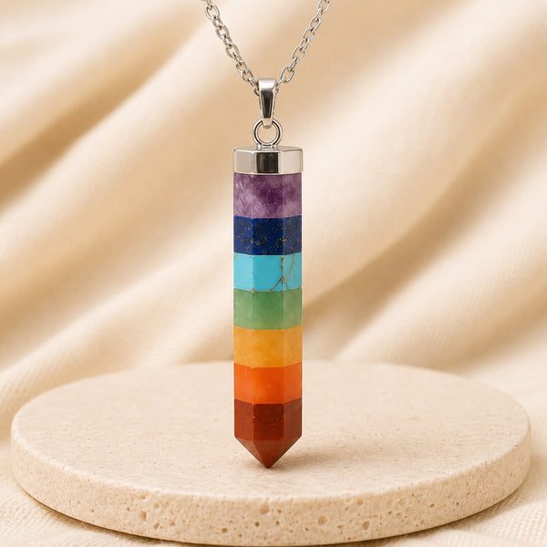 7 Chakra Pencil Pendant displayed fully on white silk cloth to show its natural colour, shape and finish