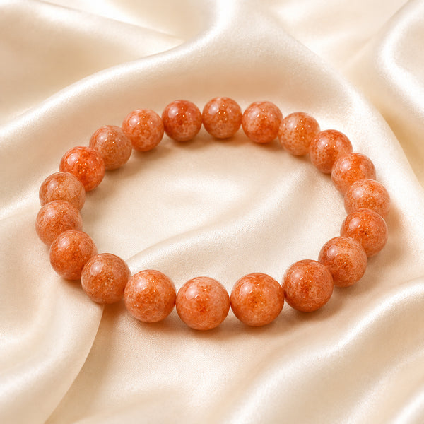 Sunstone Bracelet displayed fully on white silk cloth to show its natural colour, shape and finish