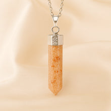 Load image into Gallery viewer, Sunstone Pencil Pendant displayed fully on white silk cloth to show its natural colour, shape and finish
