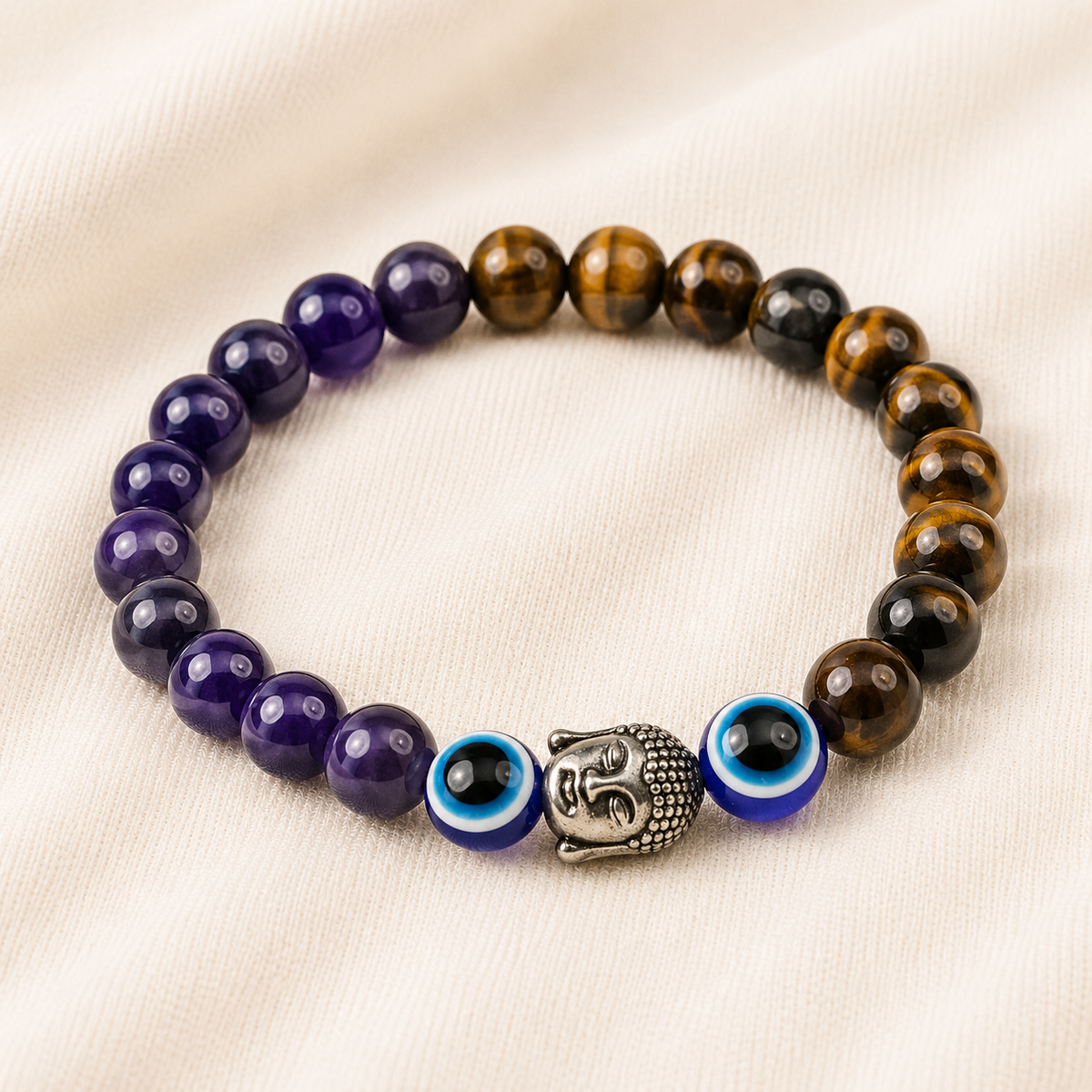 Tiger Eye, Amethyst & Evil Eye Bracelet displayed fully on white silk cloth to show its natural colour, shape and finish