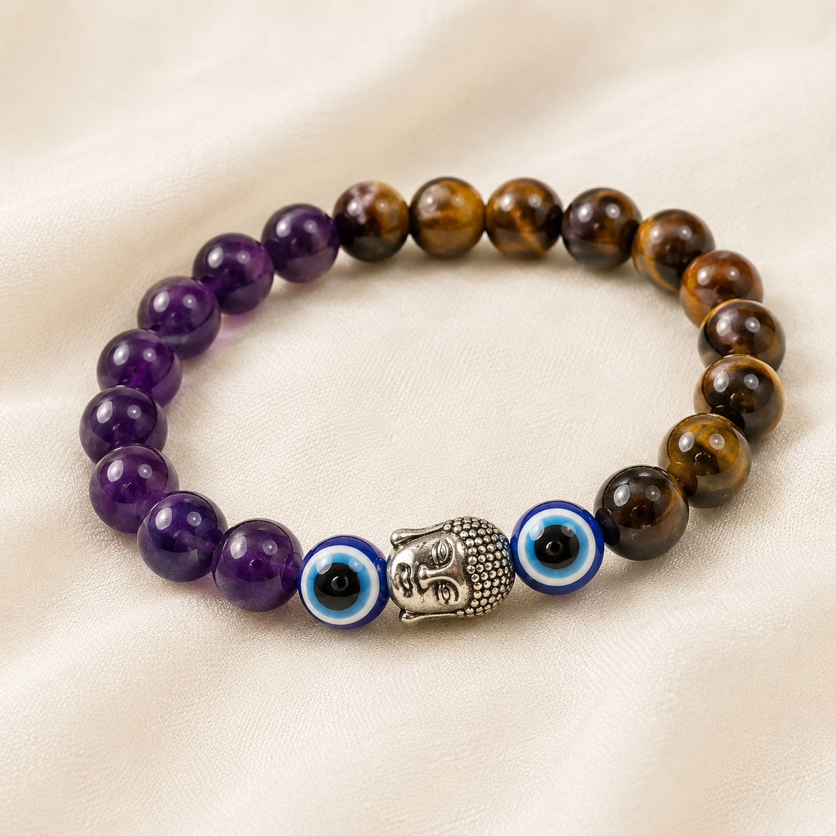 Tiger Eye, Amethyst & Evil Eye Bracelet displayed fully on white silk cloth to show its natural colour, shape and finish – tiger eye amethyst evil eye bracelet