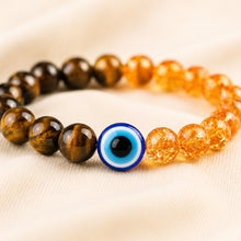 Load image into Gallery viewer, Tiger Eye, Citrine &amp; Evil Eye Bracelet displayed fully on white silk cloth to show its natural colour, shape and finish
