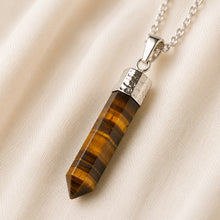 Load image into Gallery viewer, Tiger Eye Pencil Pendant displayed fully on white silk cloth to show its natural colour, shape and finish
