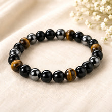 Load image into Gallery viewer, Triple Protection Bracelet displayed fully on white silk cloth to show its natural colour, shape and finish
