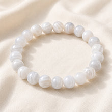 Load image into Gallery viewer, White Agate Bracelet displayed fully on white silk cloth to show its natural colour, shape and finish

