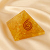 Citrine Orgone Pyramid displayed fully on white silk cloth to show its natural colour, shape and finish