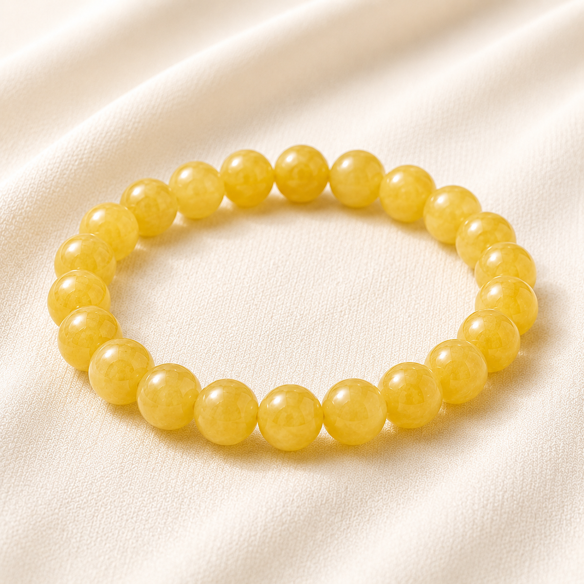 Yellow Jade Bracelet displayed fully on white silk cloth to show its natural colour, shape and finish