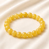 Yellow Jade Bracelet displayed fully on white silk cloth to show its natural colour, shape and finish