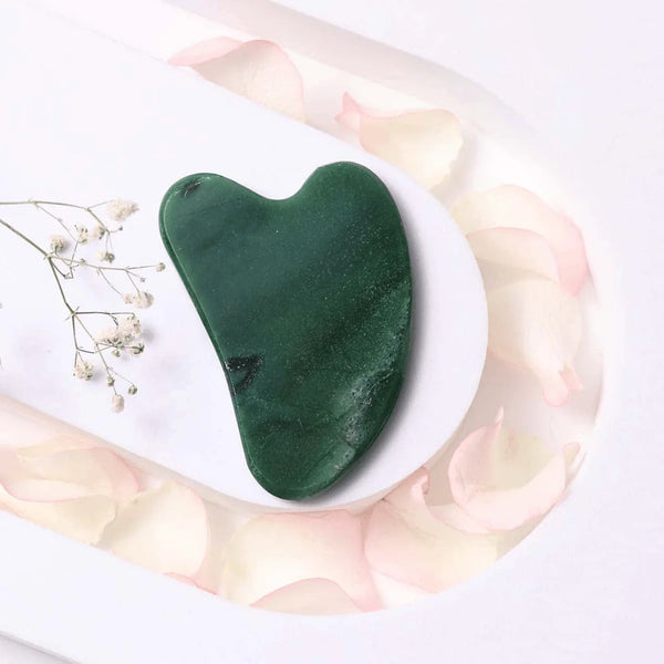 Green Jade Gua Sha tool for facial care, promoting cooling, renewing skin, and prosperity benefits.