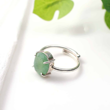Load image into Gallery viewer, Green Aventurine diamond cut oval ring placed on a white table, associated with luck, prosperity and emotional healing.
