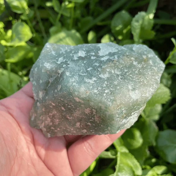 Green Aventurine raw stone resting on the hand, symbolizing luck, opportunity, and personal growth.