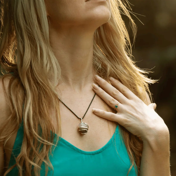 Healing jewelry fashion photo featuring a silver-wrapped black onyx pendant on a woman.