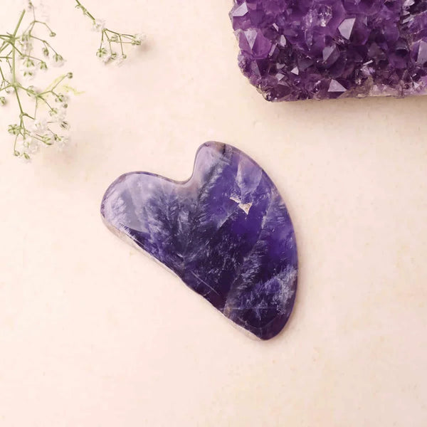 Facial Gua Sha tool made of Amethyst crystal, offering soothing and calming benefits for skin.