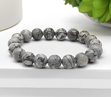 Load image into Gallery viewer, The Black Picasso Jasper bracelet with a focus on its vibrant color and unique texture.
